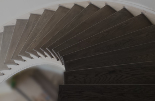 Custom curved staircase with dark wood stair treads