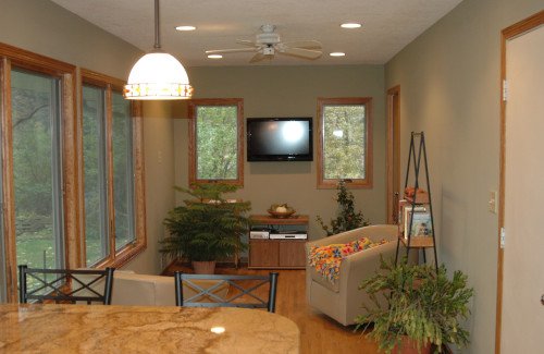 Finished lower-level living space with large windows and recessed lighting