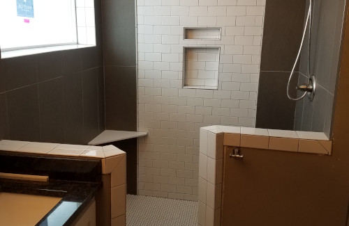 Custom walk-in shower with tile walls, built-in niches, and bench