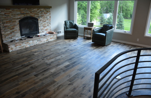Wood-look plank flooring installed in a living room with stone fireplace