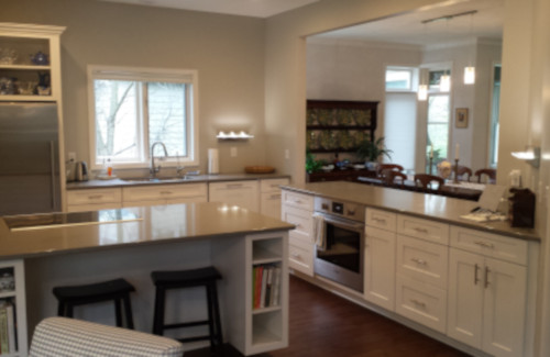 Remodeled kitchen with white cabinets, large island, and stone countertops
