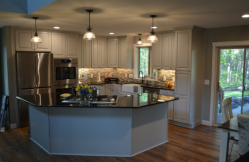 Open kitchen remodel with white cabinets, center island, and pendant lighting